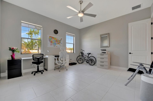 office area with light tile patterned floors, baseboards, visible vents, and ceiling fan