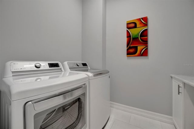 laundry room with washing machine and clothes dryer, laundry area, baseboards, and light tile patterned flooring