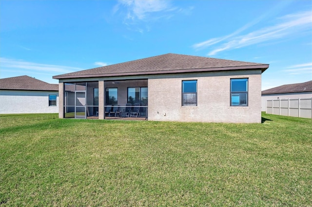 back of house with a yard, fence, a sunroom, and stucco siding