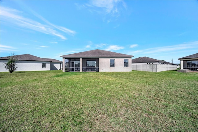 rear view of property with a yard, fence, and a sunroom