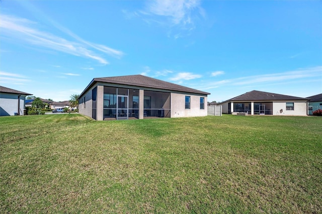 back of property featuring a lawn and a sunroom