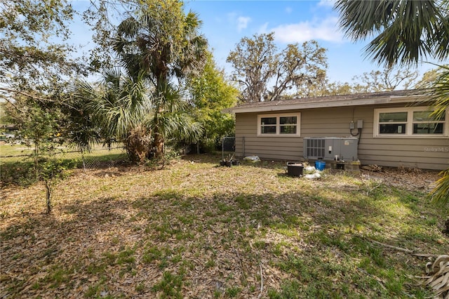 view of yard featuring central AC and fence