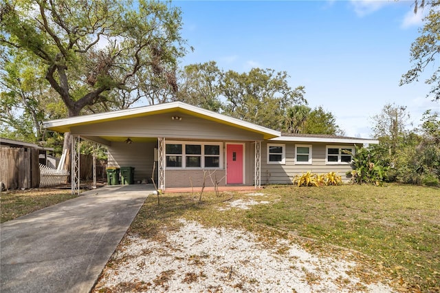 view of front of property featuring an attached carport, concrete driveway, a front lawn, and fence