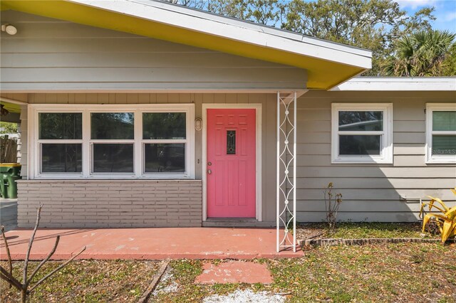 doorway to property featuring brick siding