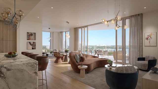 living room featuring a notable chandelier, a healthy amount of sunlight, light wood-type flooring, and a wall of windows