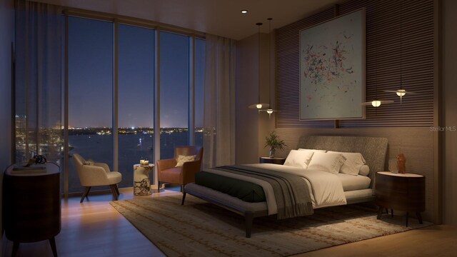 bedroom featuring a wall of windows and wood finished floors