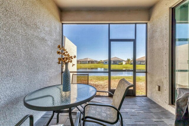 sunroom featuring a water view and a healthy amount of sunlight