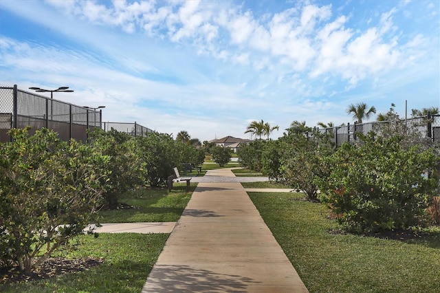 view of property's community with a yard and fence