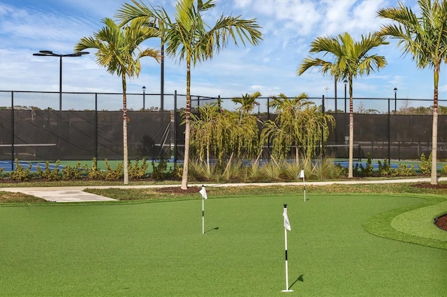 surrounding community with a tennis court and fence