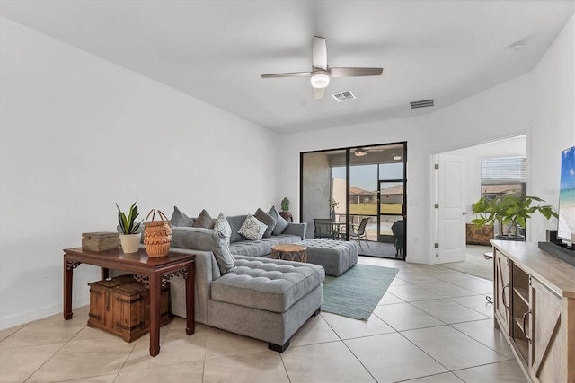 living area with light tile patterned flooring, a ceiling fan, visible vents, and baseboards