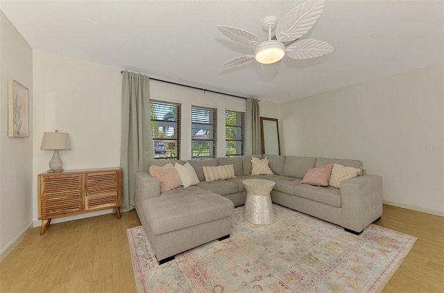 living room featuring wood finished floors, baseboards, and ceiling fan