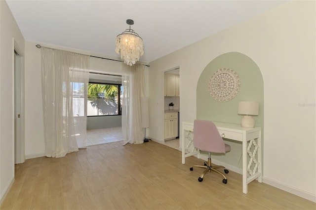 office area featuring a chandelier, baseboards, and light wood-style flooring