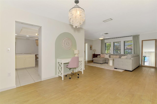 living area with light wood-type flooring, baseboards, a notable chandelier, and visible vents