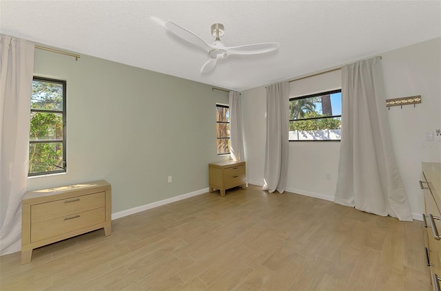 unfurnished bedroom with baseboards, light wood-type flooring, and a textured ceiling