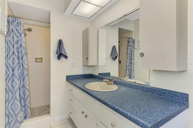 bathroom featuring tile patterned floors, tiled shower, and vanity