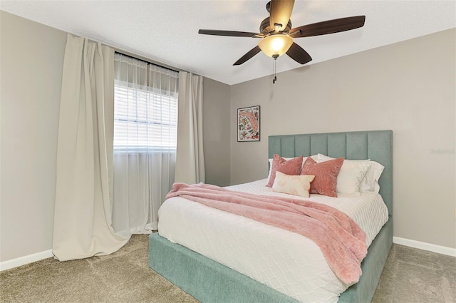 bedroom with ceiling fan, a textured ceiling, baseboards, and carpet