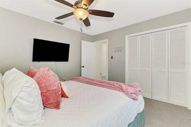 bedroom featuring a closet, visible vents, light colored carpet, and a ceiling fan