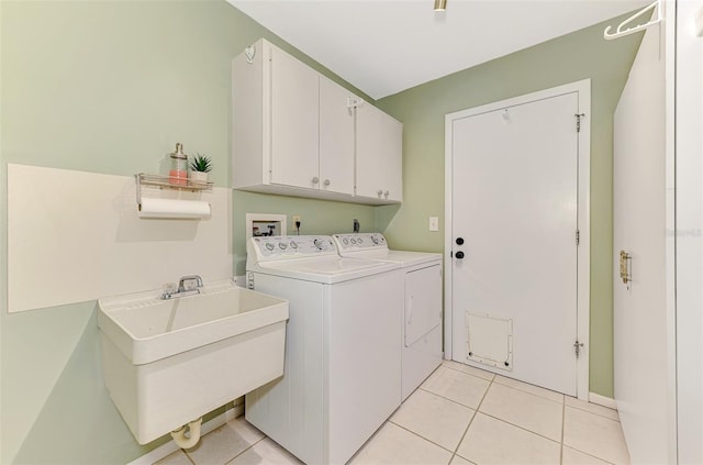 clothes washing area with a sink, cabinet space, independent washer and dryer, and light tile patterned floors