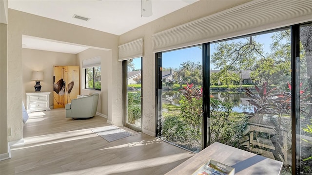 doorway to outside featuring visible vents, baseboards, and wood finished floors