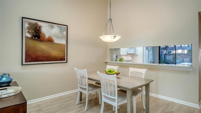 dining room featuring light wood-type flooring and baseboards