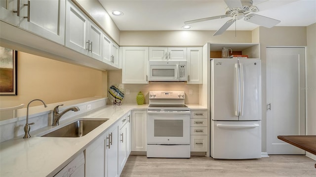 kitchen featuring white cabinets, white appliances, ceiling fan, and a sink