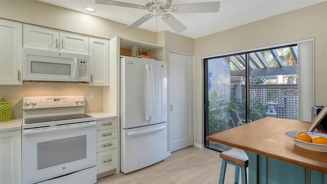 kitchen with ceiling fan, light countertops, light wood-style flooring, white cabinets, and white appliances