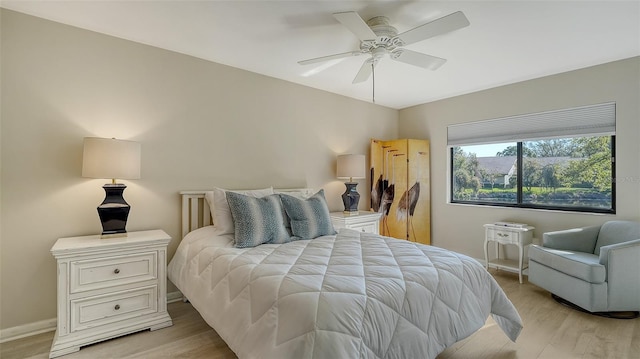 bedroom featuring a ceiling fan, baseboards, and light wood finished floors