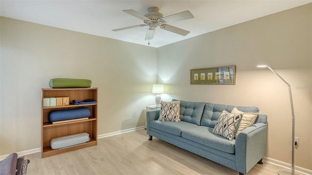 living room with wood finished floors, baseboards, and ceiling fan