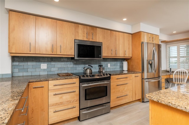 kitchen with light stone counters, recessed lighting, backsplash, and stainless steel appliances