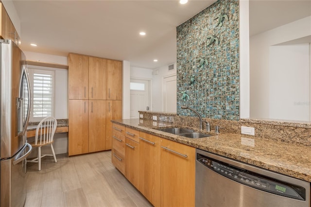 kitchen with light stone counters, recessed lighting, a sink, appliances with stainless steel finishes, and modern cabinets