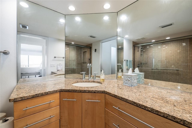 bathroom with visible vents, a stall shower, and vanity