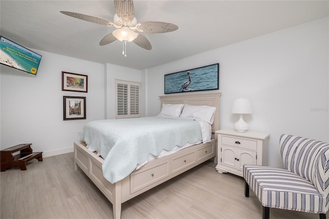 bedroom featuring baseboards, light wood finished floors, and ceiling fan