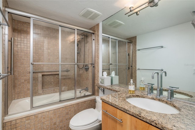 full bathroom with visible vents, bath / shower combo with glass door, vanity, and toilet