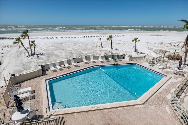 community pool with a patio and fence