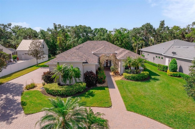 2114 147th Ct E, Bradenton, FL 34212 - view of front facade with stucco siding, decorative driveway, a front yard, fence, and french doors