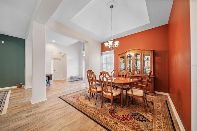 2114 147th Ct E, Bradenton, FL 34212 - dining room featuring baseboards, light wood-type flooring, arched walkways, and a notable chandelier