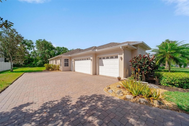 2114 147th Ct E, Bradenton, FL 34212 - view of side of property with fence, decorative driveway, a garage, and stucco siding