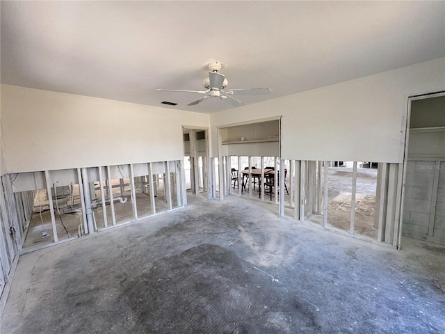 empty room with visible vents, concrete floors, and ceiling fan