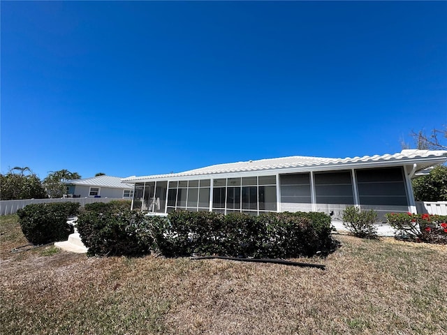 back of house with a tiled roof, fence, and a sunroom