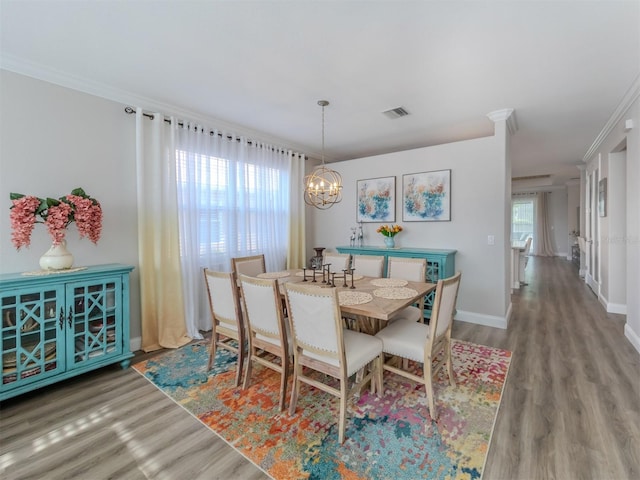 dining room featuring an inviting chandelier, wood finished floors, visible vents, and baseboards