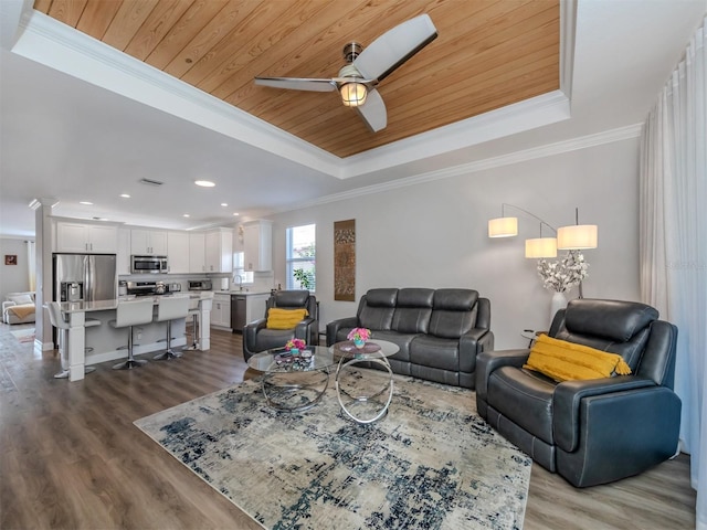 living area featuring a tray ceiling, wooden ceiling, and ornamental molding