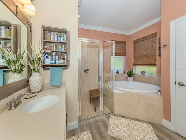bathroom with a shower stall, a garden tub, wood finished floors, and ornamental molding