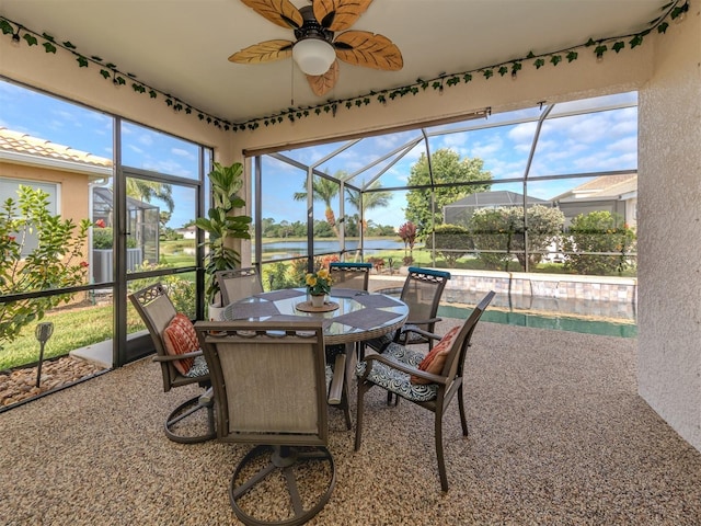 sunroom / solarium with a water view, ceiling fan, and outdoor dining space