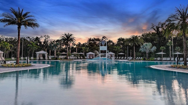 community pool with a gazebo, a patio, and a water slide