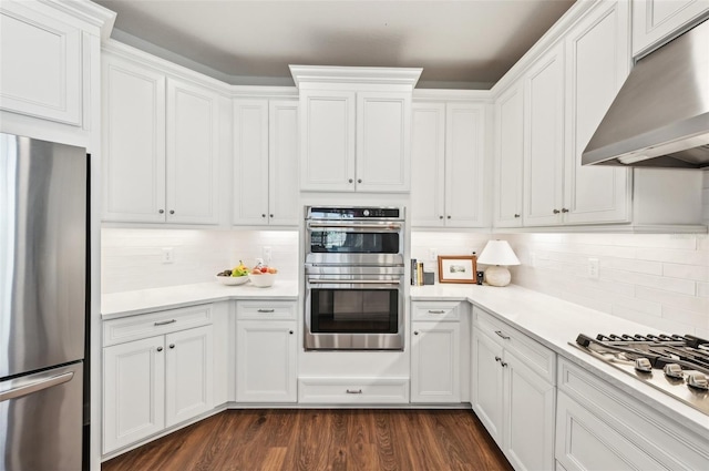 kitchen with under cabinet range hood, stainless steel appliances, white cabinetry, and light countertops