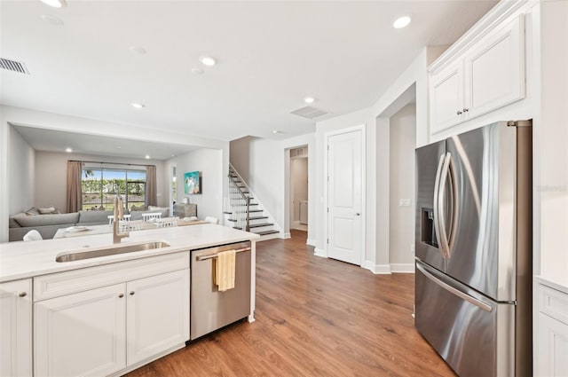 kitchen with visible vents, stainless steel appliances, open floor plan, and a sink