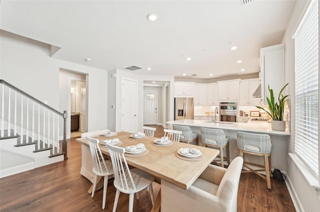 dining space featuring visible vents, dark wood-type flooring, baseboards, stairway, and recessed lighting