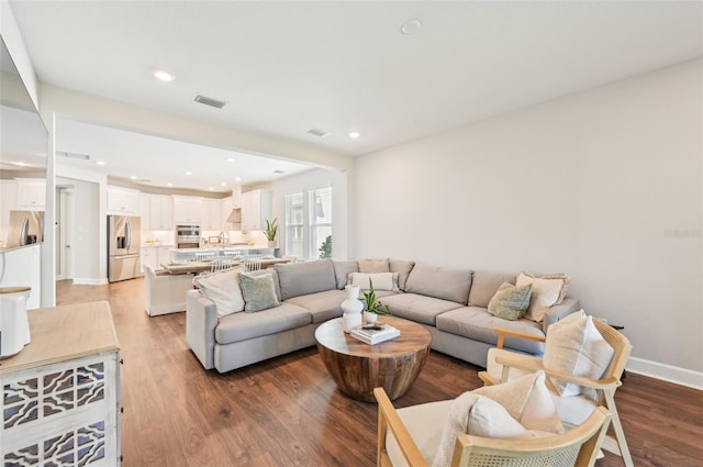 living room featuring recessed lighting, visible vents, baseboards, and wood finished floors