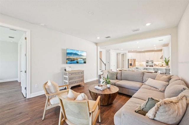 living room with visible vents, recessed lighting, dark wood-type flooring, and baseboards