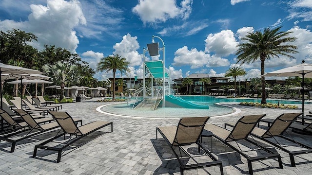 pool with playground community, a water play area, and a patio area